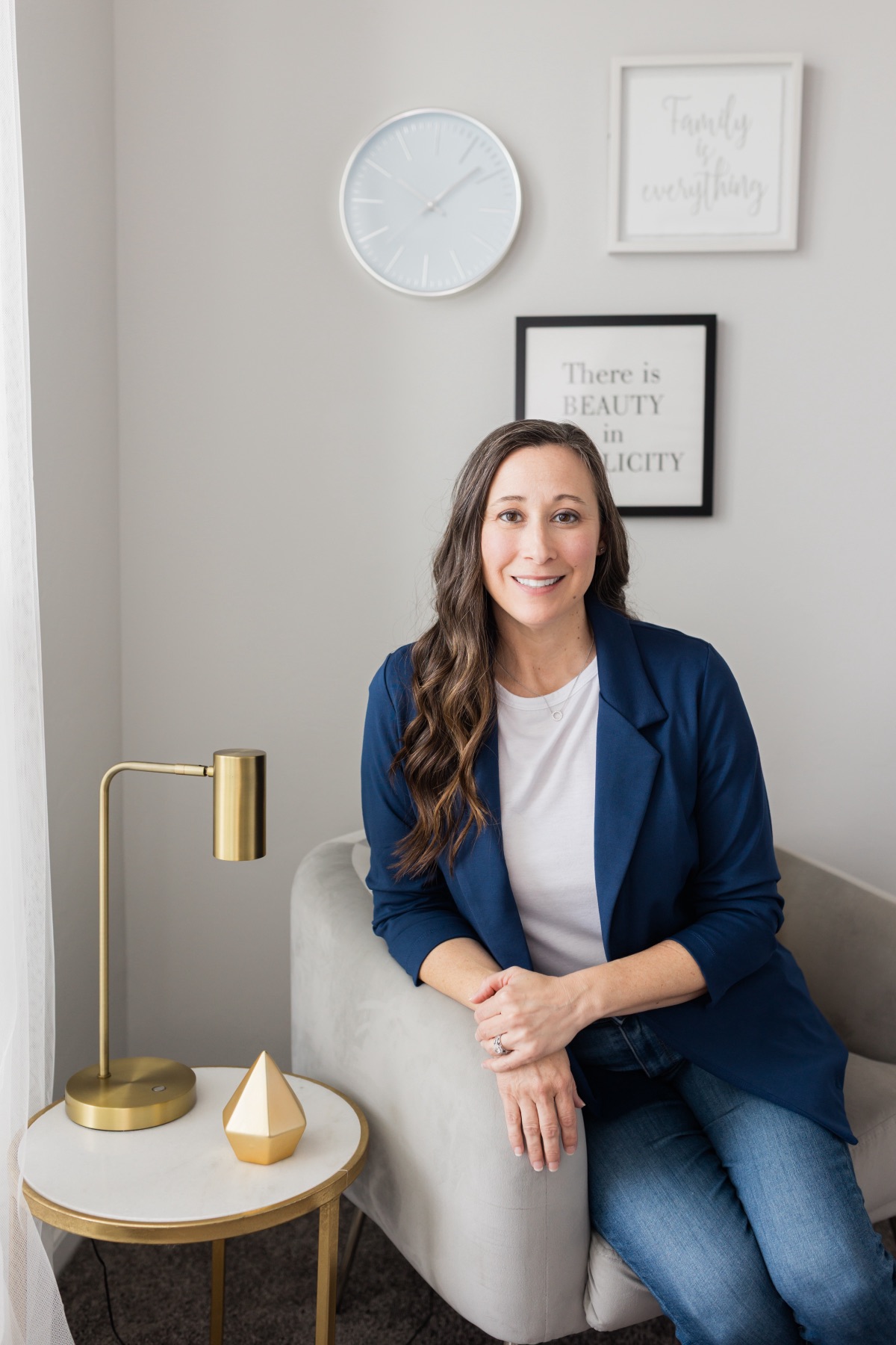 Kari at home in front of a 'family is everything' wall print
